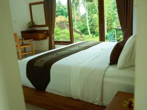乌布乌布伊甸之家住宿加早餐旅馆的卧室配有一张大白色床和窗户