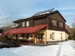 弗尔赫拉比Chata Pod Hájkem的雪上屋顶太阳能电池板的房子