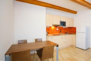 泽勒兹纳·鲁达Apartmány Nad Rybníkem的厨房配有木桌和白色冰箱。