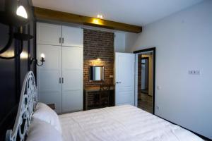 利沃夫Potocki Apartments的卧室配有白色的床和砖墙