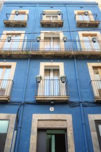 塔拉戈纳皮加尔酒店的蓝色的建筑,设有窗户和阳台