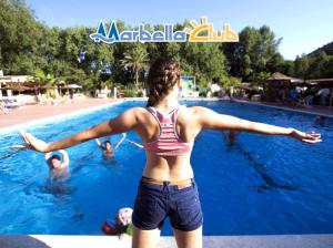 帕利努罗维拉吉奥玛贝拉俱乐部酒店的站在游泳池中的女人,手臂伸出