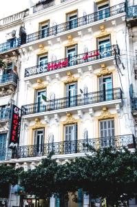 阿尔及尔阿尔及尔城市酒店的带阳台的白色建筑,上面有标志