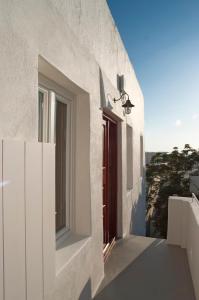 米克诺斯城Casal Paleologos Villa的白色的房子,有红色的门和窗户