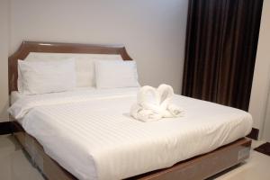 北碧奈亚广场公寓的一张带两个白色毛巾的床