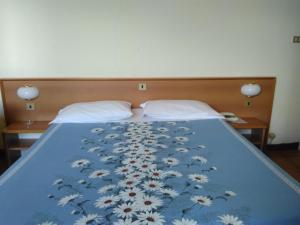 拉帕洛Albergo Bandoni的一张床上,床上有鲜花,有蓝色的毯子