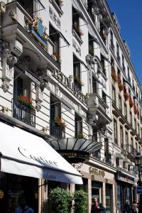 巴黎Hotel Westminster的一座高大的白色建筑,窗户上装有花盒