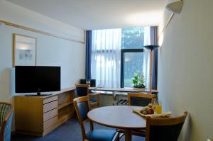 里斯本VIP行政伊甸园公寓式酒店的酒店客房设有两张桌子和电视
