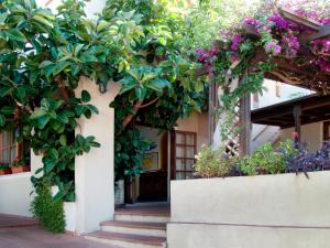 波蒙特Hotel Corallo的花卉和植物的建筑物入口