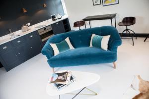 布里德波特Little Boutique Club的客厅配有一张蓝色的沙发,配有一张桌子