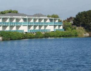 阿拉米达珊瑚公寓套房酒店的水体岸边的建筑物