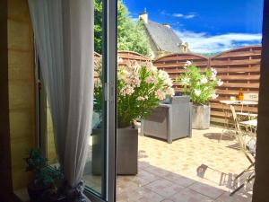 萨尔拉拉卡内达La Clef des Songes B&B de charme - Sarlat Centre - Parking gratuit - Piscine et espace bien-être à 400mètres的从种有植物的窗户欣赏庭院的景色