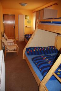 比尔森Penzion W的一间卧室配有两张双层床和椅子