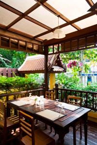 曼谷兰普树屋精品酒店的庭院里配有一张带椅子和遮阳伞的木桌