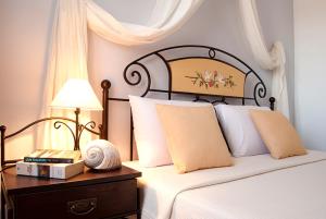 迈洛波塔斯Island House Mare的一间卧室配有一张床和一张带台灯的桌子