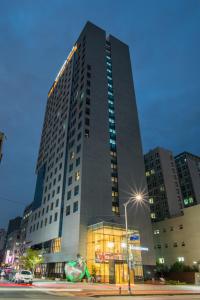 首尔东大门IBC酒店的一座高大的建筑,前面有灯