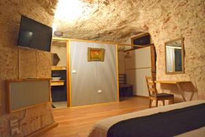 库伯佩迪Dug Out B&B的洞穴内的卧室,配有一张床和一张书桌
