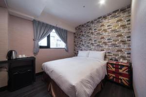 台北趣旅馆．林森馆的一间卧室设有一张床和砖墙