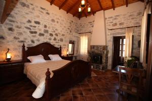 利梅尼瓦西利奥斯公寓酒店的一间卧室设有一张床和石墙