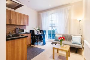 伦敦艾丽西亚南肯辛顿公寓的厨房以及带沙发和桌子的客厅。