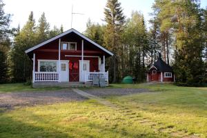 Vikajärvi阿霍森罗曼莫吉特度假屋的一座红色的小房子,在院子里设有一个车库