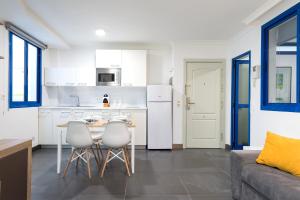 大加那利岛拉斯帕尔马斯Suites Apartamento 17的厨房以及带桌椅的起居室。
