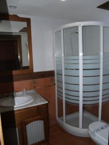 莱德斯马Hotel Rural El Rocal的一间带玻璃淋浴和水槽的浴室