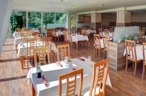 道尼库宾奥拉瓦假日公园的餐厅设有白色的桌子和木椅