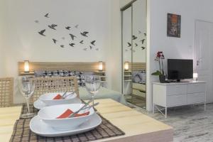 布达佩斯Standard Apartment by Hi5-Liszt Ferenc Square的用餐室配有桌子、玻璃杯和墙上的鸟类