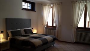 加尔达湖滨卡萨弗朗西斯酒店的一间卧室设有黑白床和2个窗户。