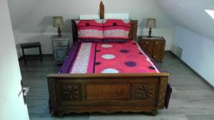 TalmontiersChez Tripp的一间卧室配有一张带红色棉被的木床