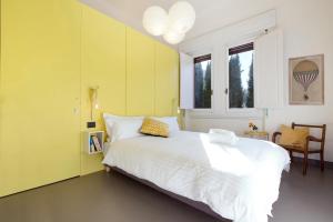 佛罗伦萨莫斯佛罗伦萨旅馆的卧室配有白色的床和黄色的墙壁