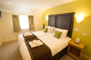 韦克菲尔德Wakefield Limes Lodge的酒店客房,配有两张带毛巾的床