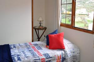 巴尔塞基略Casa Paco Las Vegas的一间卧室配有一张带红色枕头的床和窗户