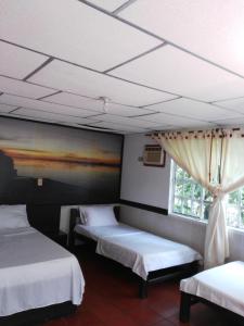 比亚维森西奥Hotel Campestre Kosta Azul的客房设有两张床和窗户。