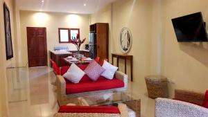 格拉纳达Hotel Plaza Marbella Granada的客厅配有红色椅子和桌子