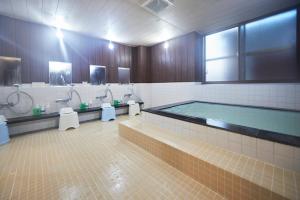 大崎市古川精选酒店的带浴缸和两个盥洗盆的大浴室