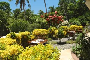 Guindulman桂杜尔曼湾旅游宾馆的花园设有桌椅和鲜花