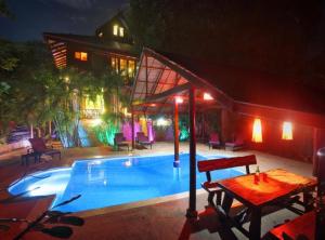 西塔努7 Bedroom Seafront Villa Phanghan SDV232-By Samui Dream Villas的房屋旁带桌子的游泳池