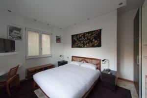 科莫罗莎蓝光住宿加早餐旅馆的卧室配有白色的床、书桌和窗户。
