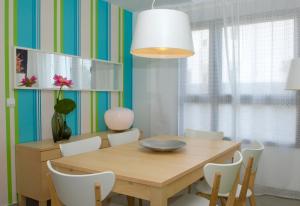 科斯塔特吉塞Villas Las Maretas的一间带木桌和白色椅子的用餐室