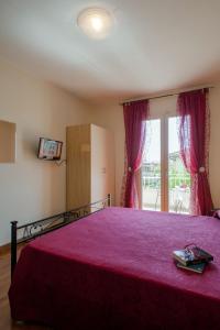蒙蒂尼奥索阿尔特里玫瑰住宿加早餐酒店的一间卧室配有一张红色床罩的床