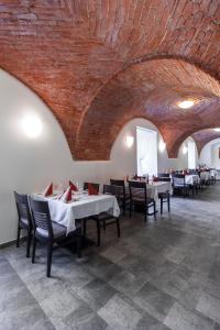 瓦尔季采塞雷特酒店的一间设有桌椅的用餐室和砖墙