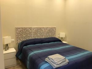 坎波巴索Dimora Spina in centro的一间卧室配有一张带2个床头柜和2盏灯的床。