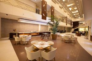 胡富夫格兰特百合套房酒店的大楼内带桌椅的餐厅