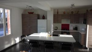 TalmontiersChez Tripp的厨房配有白色的桌子和冰箱。