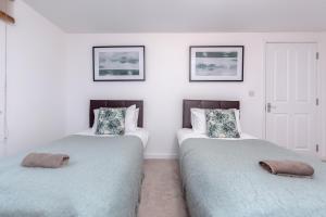 希灵登Royal Apartments - Heathrow的两张睡床彼此相邻,位于一个房间里