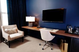 卡温顿Hotel Covington Cincinnati Riverfront的客房设有一张桌子、一把椅子和一台电视