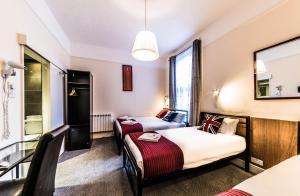 伦敦萨巴梅兰德酒店的酒店客房,设有两张床和镜子