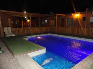 圣佩德罗·德·阿塔卡马帕布利托旅馆的游泳池晚上有紫色灯光